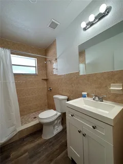 a bathroom with a sink a toilet a mirror and shower