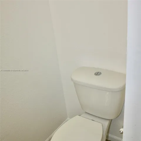 a white toilet sitting next to a shower