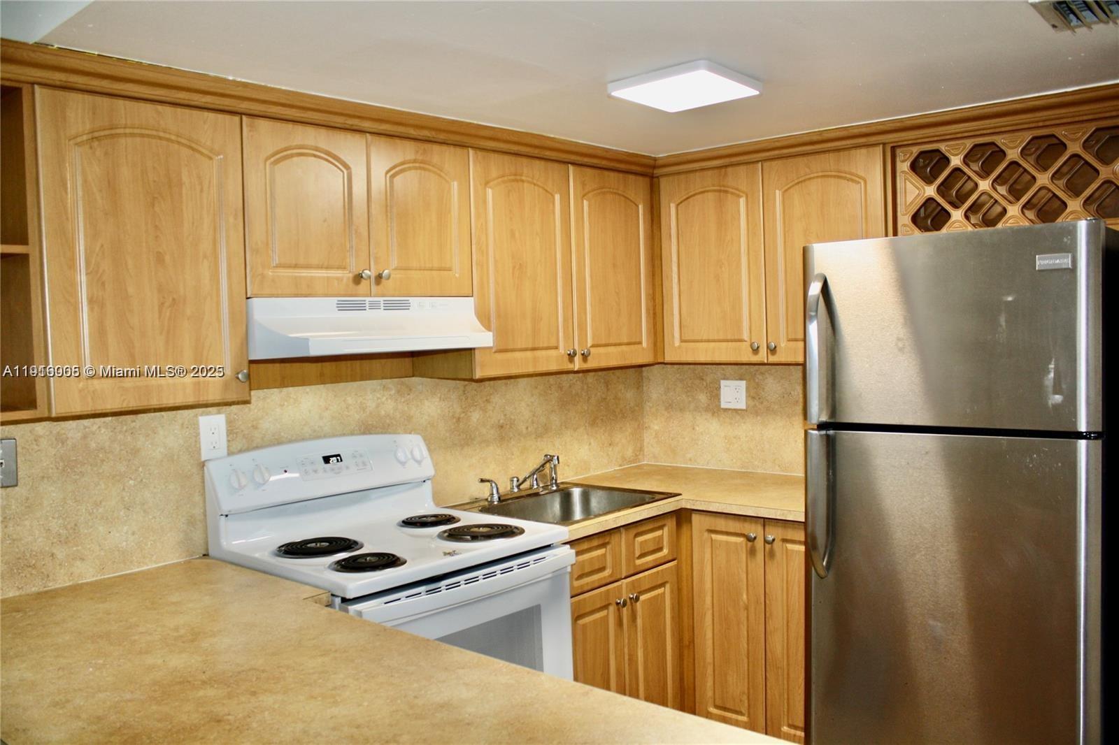 2079 West 54th Terrace, Unit 29 Hialeah, FL 33016 - Photo 15 of 43 a kitchen with a refrigerator a stove top oven