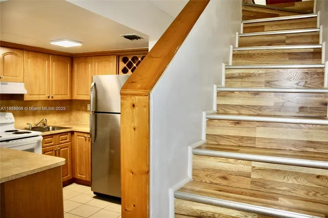 a view of a kitchen with wooden floor and staircase