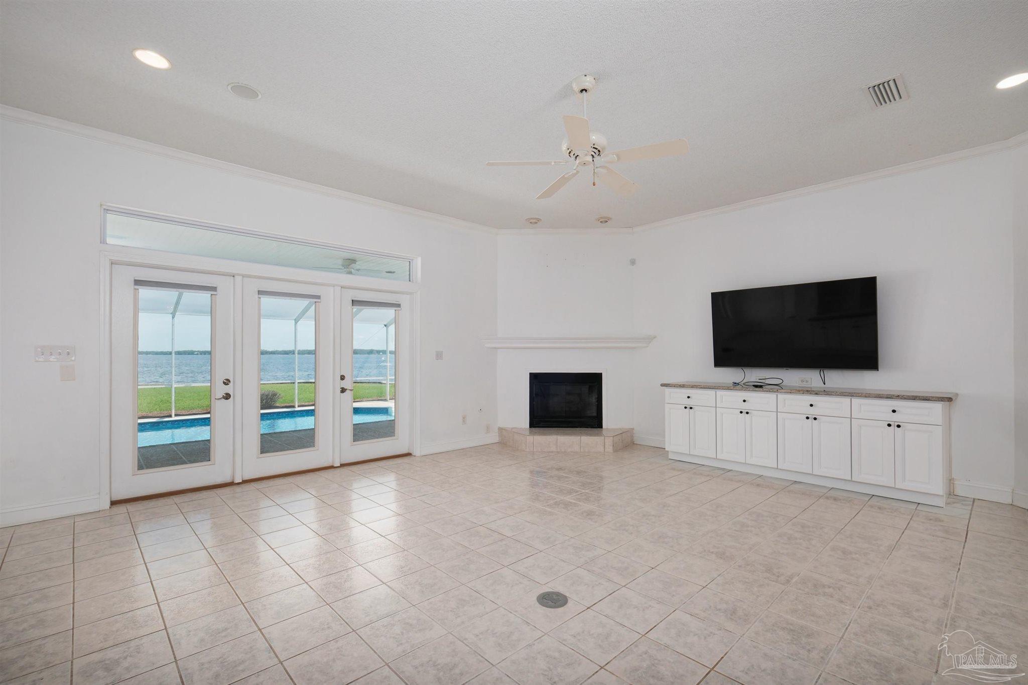 5450 North Shore Road Pensacola, FL 32507 - Photo 16 of 62 a view of an empty room with a fireplace and a flat screen tv