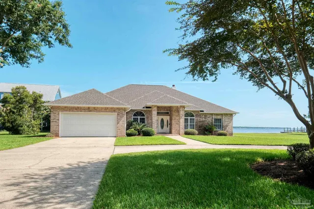 a front view of a house with a garden and yard
