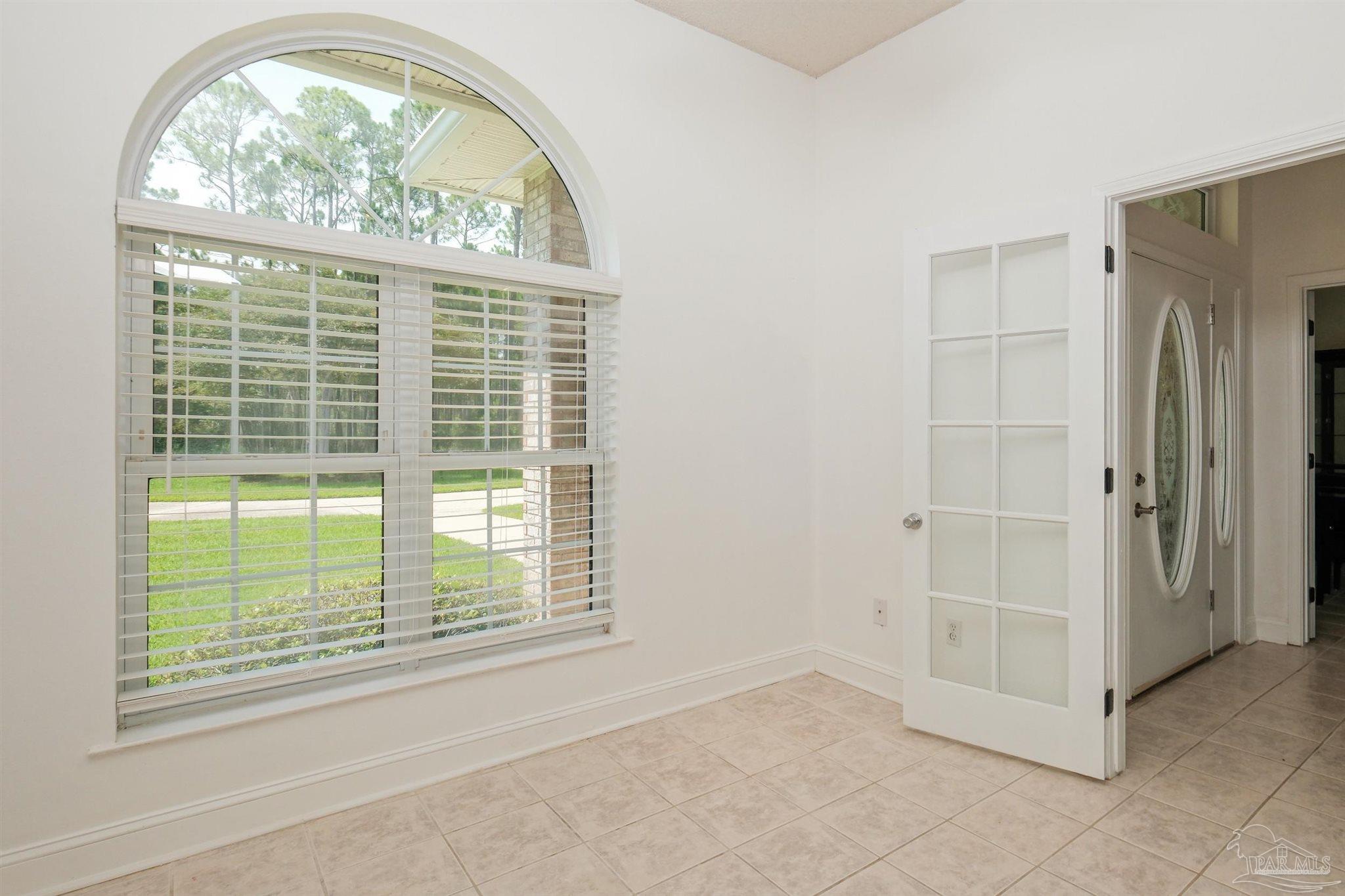 5450 North Shore Road Pensacola, FL 32507 - Photo 22 of 62 an empty room with a fireplace mirror and windows