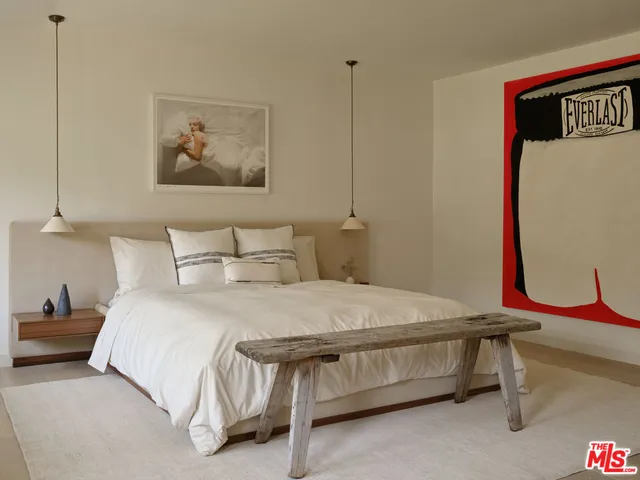 a bedroom with a bed and wall painting