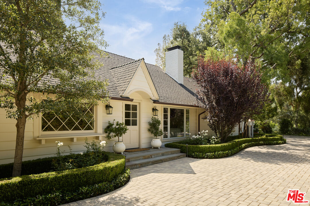 17333 Rancho Street Encino, CA 91316 - Photo 3 of 30 a view of a white house with a chairs in a patio