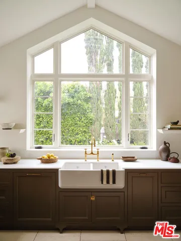a kitchen with white cabinets and sink