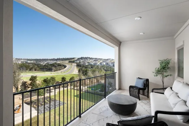a view of a balcony with furniture and an ocean