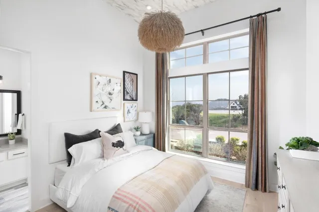 a bedroom with a bed and a large window