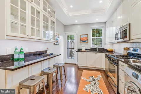 a kitchen with stainless steel appliances granite countertop a stove and white cabinets