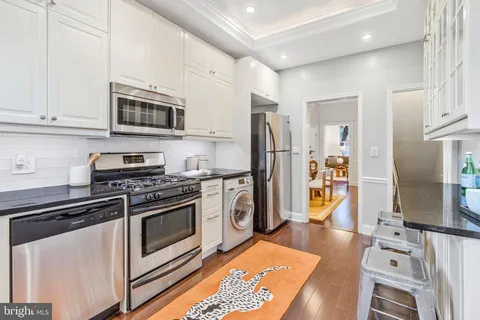 a kitchen with stainless steel appliances granite countertop a refrigerator stove and sink