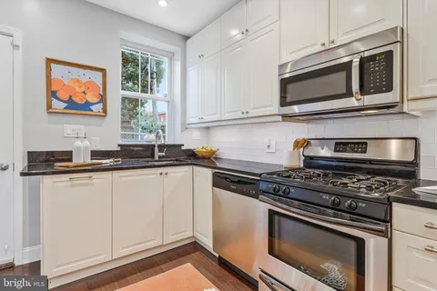 a kitchen with stainless steel appliances granite countertop a stove microwave and sink