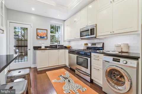 a kitchen with stainless steel appliances granite countertop a refrigerator and a stove top oven