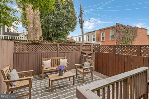 a balcony with wooden floor and outdoor seating