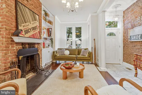 a living room with furniture a fireplace and a chandelier