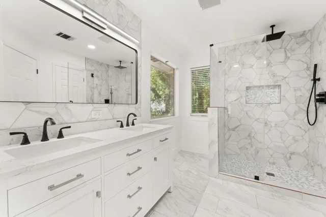 a bathroom with a shower sink and mirror