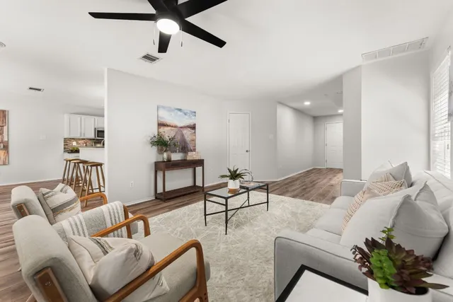 a living room with furniture and a ceiling fan