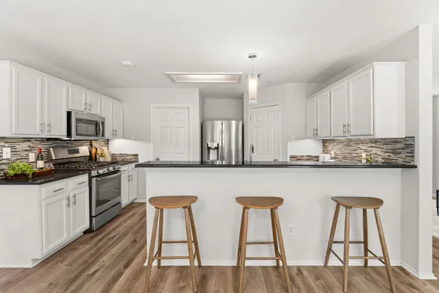 a kitchen with white cabinets and stainless steel appliances