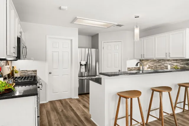 a kitchen with stainless steel appliances granite countertop a refrigerator and a stove top oven