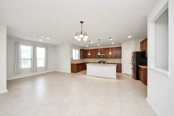 a large kitchen with stainless steel appliances kitchen island granite countertop a stove a refrigerator a sink a island and chairs