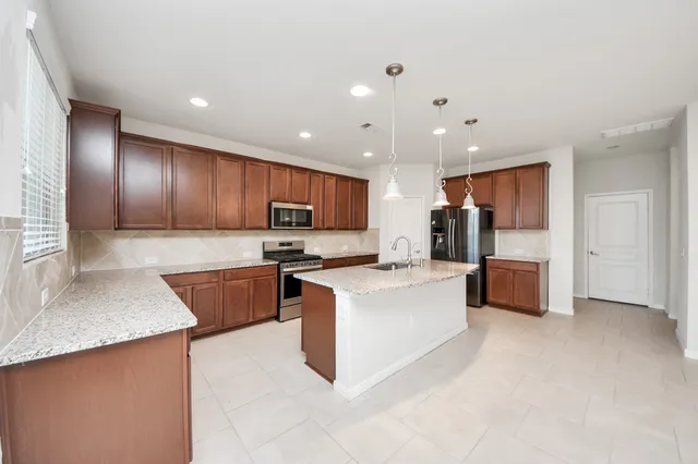 a kitchen with kitchen island a sink stove and refrigerator