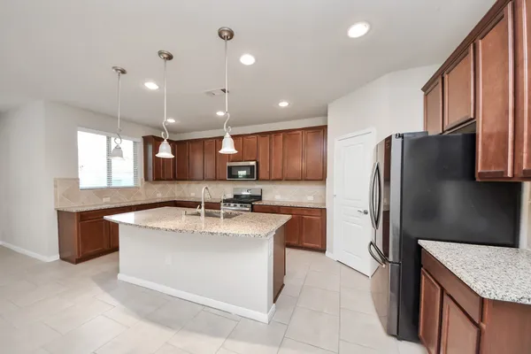a large kitchen with granite countertop a sink and cabinets