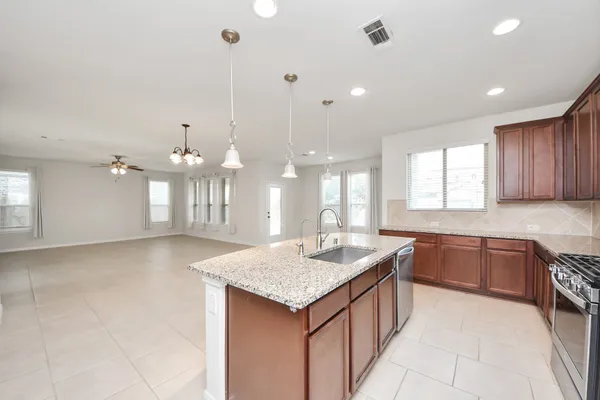 a kitchen with stainless steel appliances kitchen island granite countertop a stove and a refrigerator