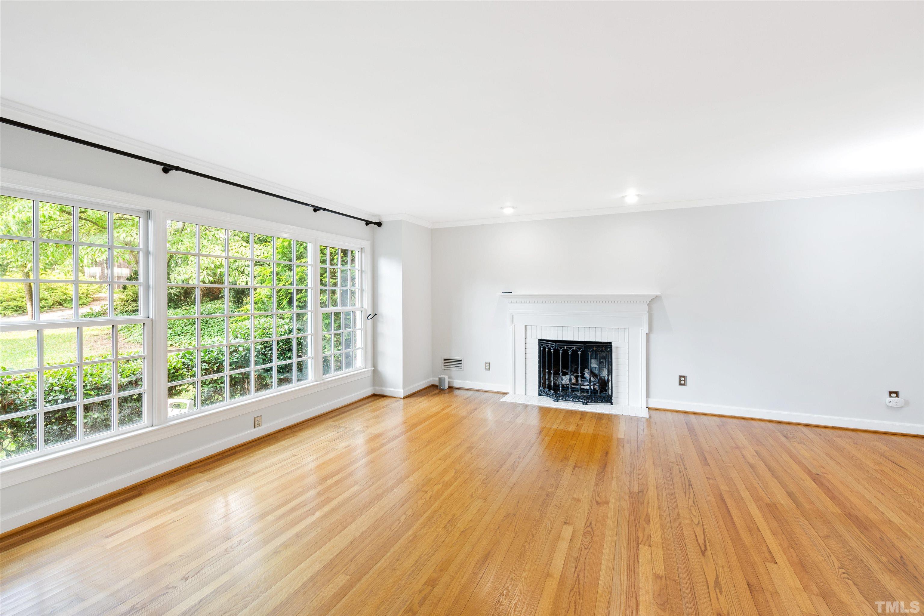 1320 Diehl Street Raleigh, NC 27608 - Photo 7 of 47 a view of an empty room with wooden floor and a window