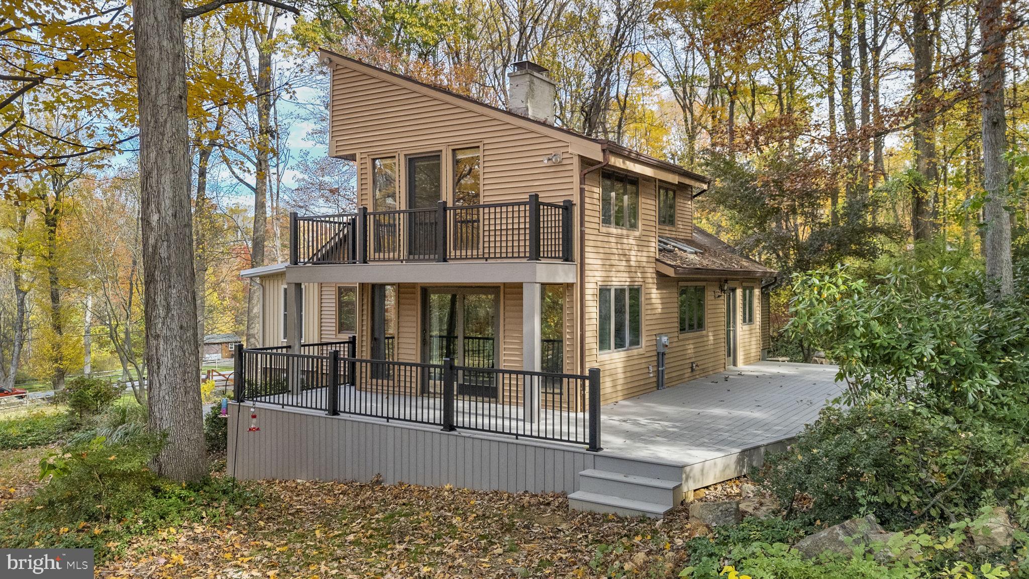 10 Woods Road Elverson, PA 19520 - Photo 1 of 49 a view of a white house with large windows and a small yard