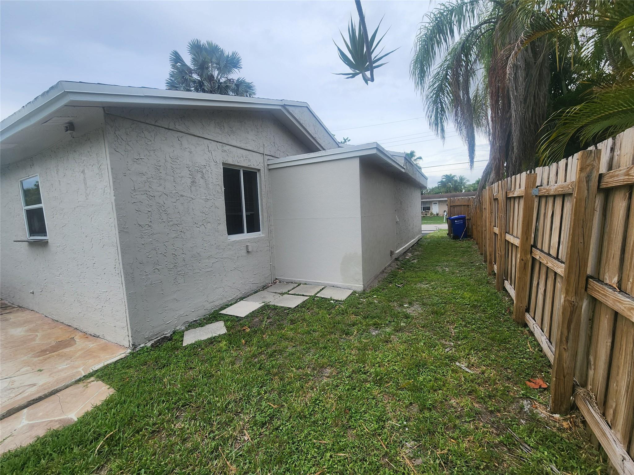 6133 Hogan Creek Road Margate, FL 33063 - Photo 2 of 5 a yellow house with a yard in front of it