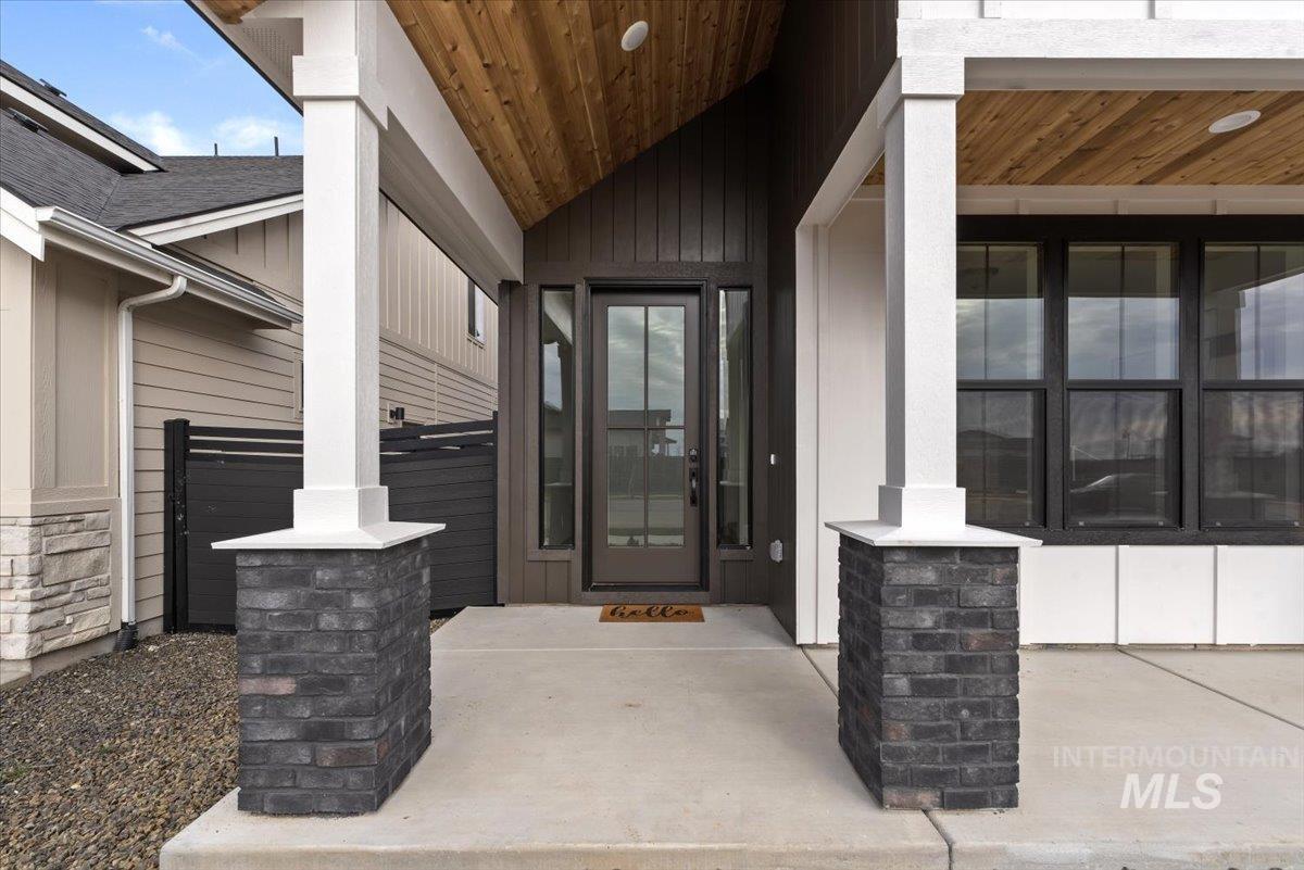7586 West Centerline Street, Unit FREMONT Eagle, ID 83616 - Photo 7 of 37 Doorway to property with stone siding, a porch, and board and batten siding
