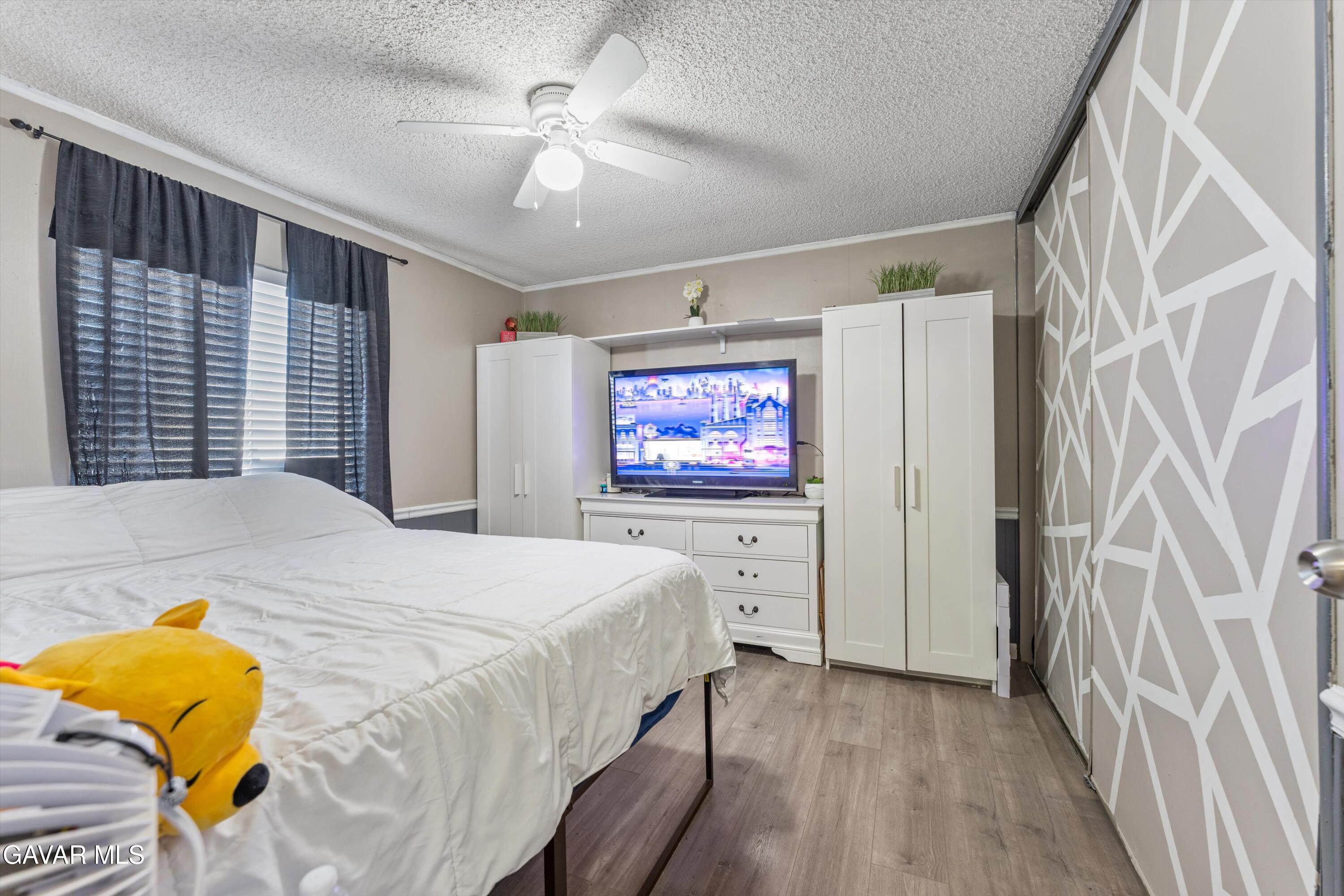 5711 Columbia Way Lancaster, CA 93536 - Photo 4 of 21 a bedroom with a bed and a chandelier