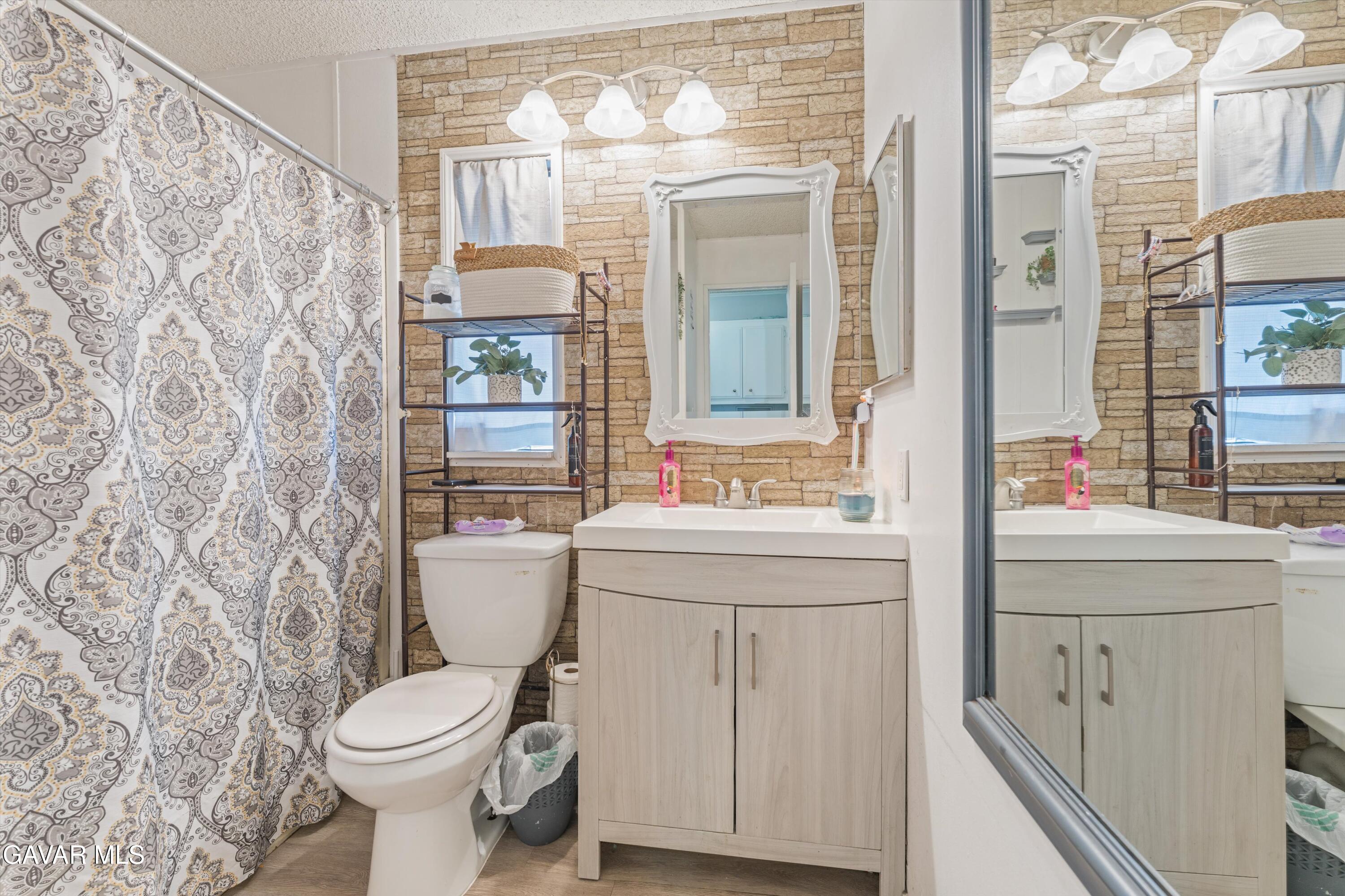 5711 Columbia Way Lancaster, CA 93536 - Photo 5 of 21 a bathroom with a sink a toilet and shower