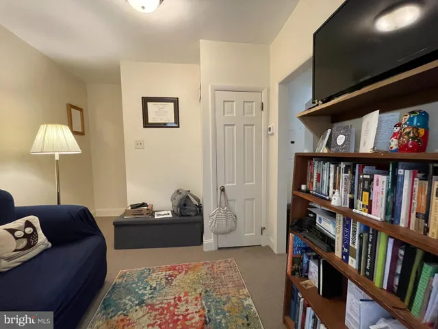 a living room with furniture and a book shelf