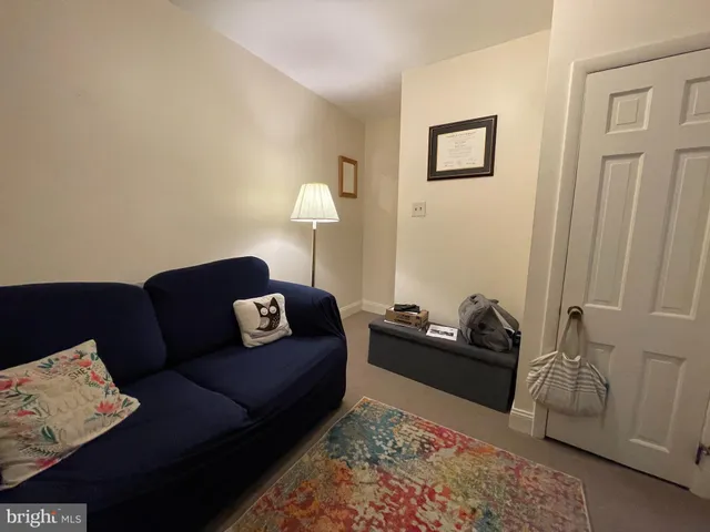 a living room with furniture and baby crib