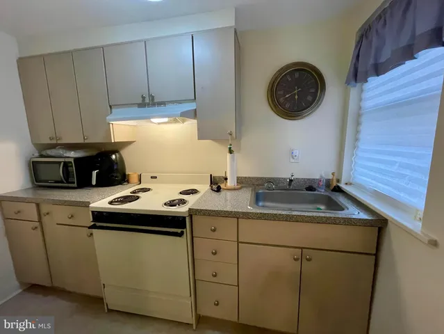 a kitchen with a sink a stove and cabinets