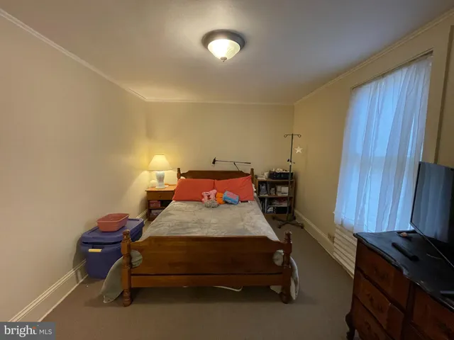 a bedroom with a bed and a lamp next to window