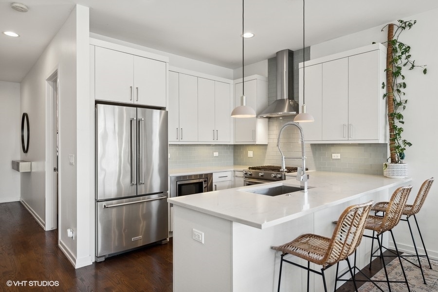 1033 South Racine Avenue, Unit 3NR Chicago, IL 60607 - Photo 7 of 34 a kitchen with stainless steel appliances a refrigerator a stove a sink and white cabinets with wooden floor