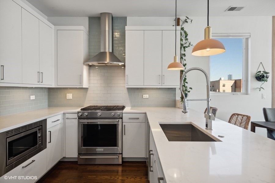 1033 South Racine Avenue, Unit 3NR Chicago, IL 60607 - Photo 8 of 34 a kitchen with a stove and a wooden floor