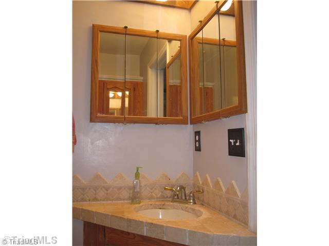 3220 Rockingham Road High Point, NC 27265 - Photo 10 of 16 Master Bath/Spa. Pretty fixtures, TILE, stand up shower, double medicine cabinets PLUS huge cabinets over toilet allow for lots of storage in the master bath.