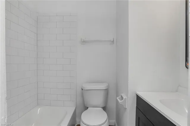 a white toilet sitting next to a bath tub