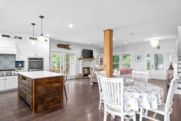 a living room with furniture and kitchen view with wooden floor