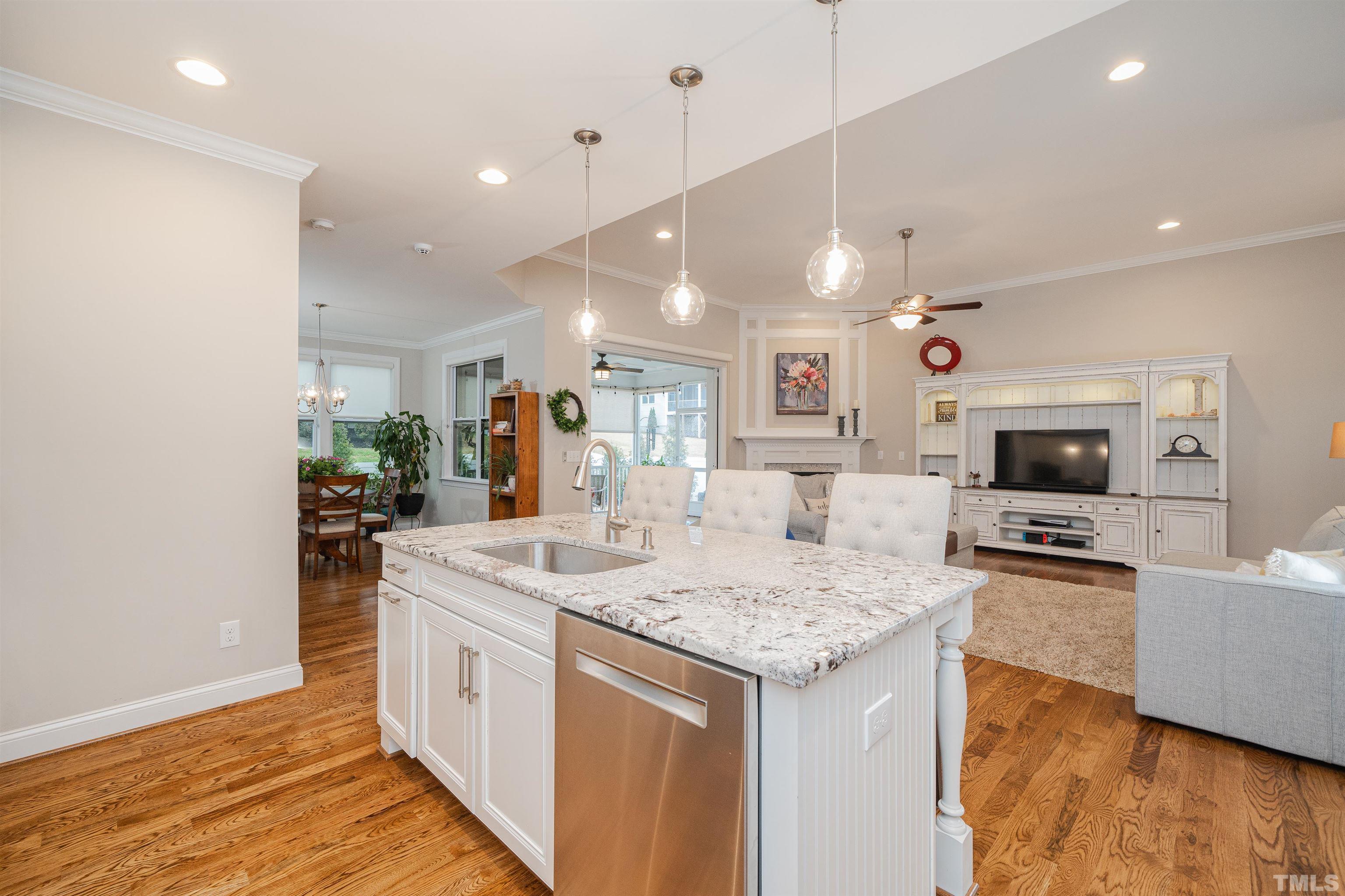 616 Connington Way Rolesville, NC 27571 - Photo 22 of 51 a large kitchen with kitchen island a flat screen tv and a wooden floor