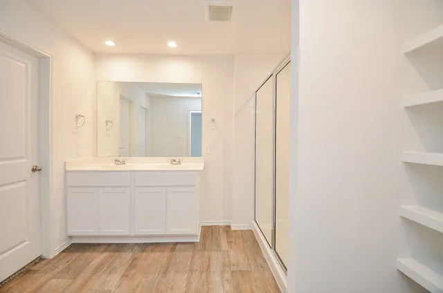a bathroom with a sink a mirror and a shower