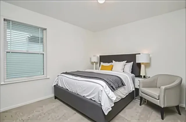 a bed sitting in a bedroom next to a window