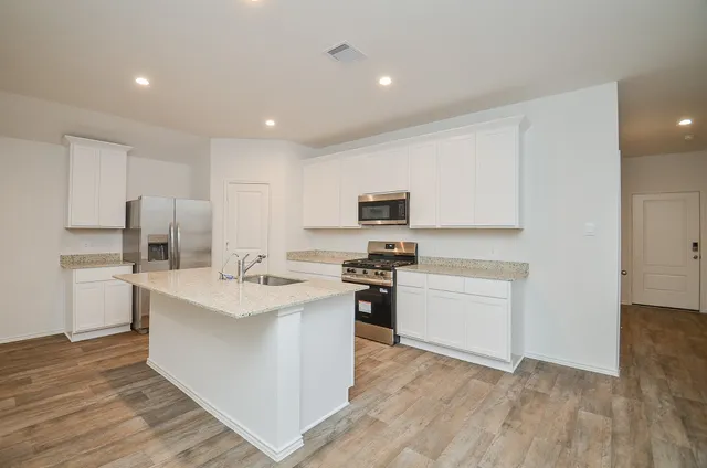 a kitchen with white cabinets stainless steel appliances and sink