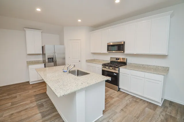 a kitchen with granite countertop a stove top oven a sink and a granite counter top