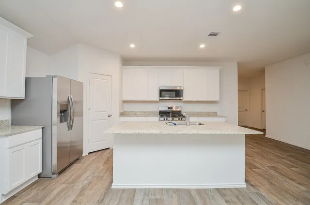 a kitchen with stainless steel appliances a sink and refrigerator