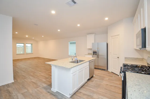 a kitchen with stainless steel appliances granite countertop a sink stove and refrigerator