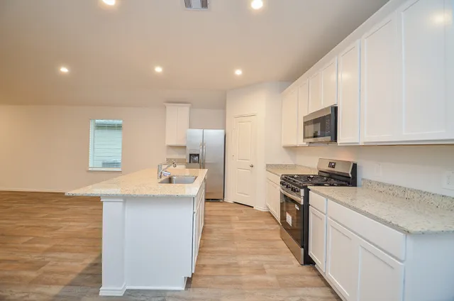 a kitchen with stainless steel appliances granite countertop a sink stove and refrigerator