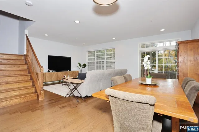 a view of a dining room with furniture a rug and wooden floor